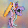 Full view of the chunky keychain featuring a lilac mini gaming controller and a multicolored Fuzzy Keychain tassel in pastel pink, purple, and mint