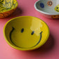 Hand-painted yellow ceramic smile bowl with glossy finish and happy face detail