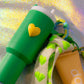 Detail view of green Stanley in The Pocket Key Charm with yellow heart design