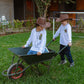 Two kids wearing Wilder Than The West long sleeve t-shirts playing with wheelbarrow