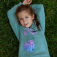 Kids mint green fleece jogger set with You Rock print and hand stitch pocket detail worn outdoors