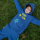 Child wearing You Rock denim blue fleece hoodie and jogger set outdoors